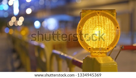 Yellow caution light in the street at night
