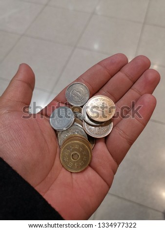 a photo of Japanese yen coins  on a hand of a man 