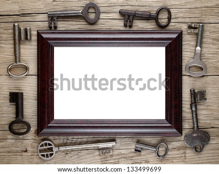 Photo frame and vintage keys on wooden background