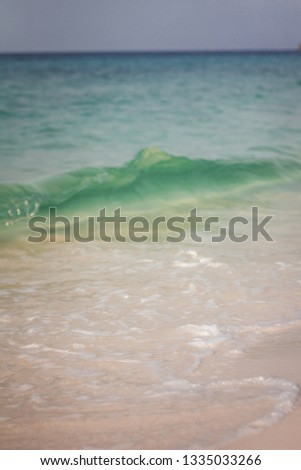Soft waves of ocean at tropical long white sand beach with many footprint on the beautiful island of Koh Rong, Cambodia