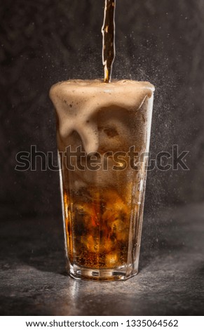 Glass of soda with ice on a dark background. Carbonated beverages. Selective fokus.