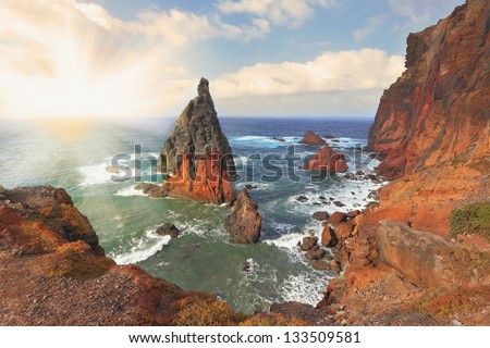  Picturesque colorful cliffs and islands.  The eastern tip of the island of Madeira.Madeira. Shining rays of the sun reflected in the water