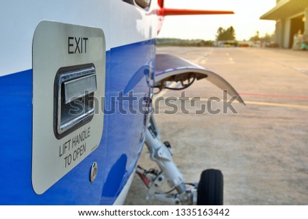 Helicopter parking on ramp. Helicopter   outside door handle sign . Helicopter sikorsky s76 in front of hangar 