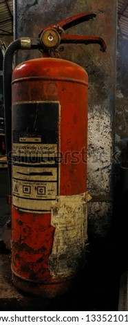 Old fire extinguisher,old Red fire extinguishers available in fire emergencies ,Obsolete and dirty fire extinguisher in factory  .
