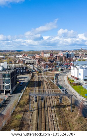 Aerial view of trains approaching, arriving, leaving Stoke on Trent train station on a warm day shortly after a storm, commuter transportation system to the north and south in the midlands