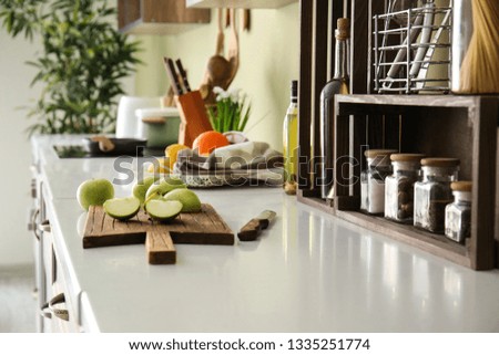 Fresh apple with cutting board on counter in kitchen