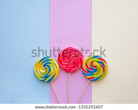 Different tasty colorful candies on pastel color background