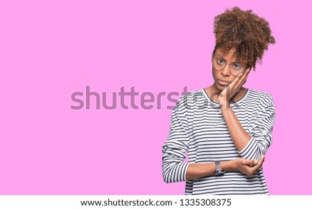 Beautiful young african american woman wearing glasses over isolated background thinking looking tired and bored with depression problems with crossed arms.