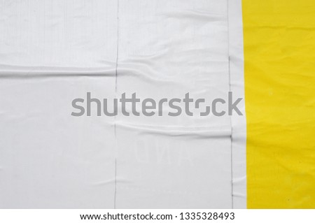 overlapping layers of white and yellow street posters