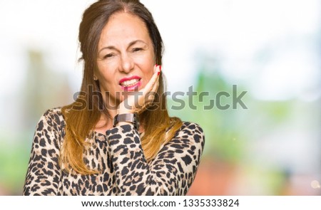 Beautiful middle age woman wearing leopard animal print dress thinking looking tired and bored with depression problems with crossed arms.