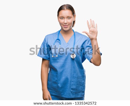 Young caucasian doctor woman wearing medical uniform over isolated background showing and pointing up with fingers number five while smiling confident and happy.