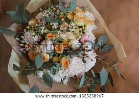 Bouquet of flowers in yellow, white, green shades. Ingredients: roses, dahlia, berries, eucalyptus, cotton flower, chrysanthemum, freesia, willow, tulips, ornamental cabbage. Flower composition.