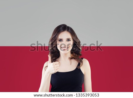 Cute young woman showing thumb up on the Poland flag background. Travel and learn polish language concept Royalty-Free Stock Photo #1335393053