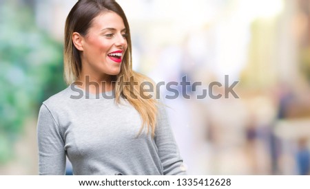 Young beautiful worker business woman over isolated background looking away to side with smile on face, natural expression. Laughing confident.