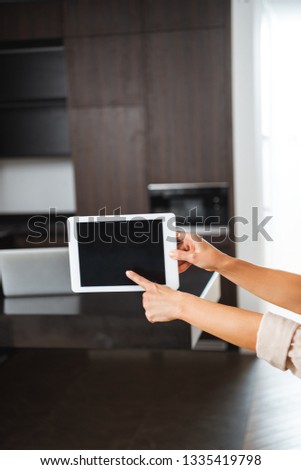 selective focus of woman pointing at blank screen of digital tablet