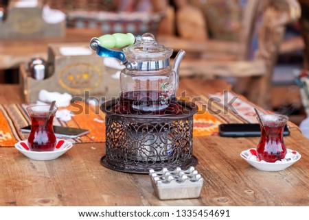 Turkish tea in traditional glasses on table. Traditional Turkish tea set: glass cup of tea, painted teapot.