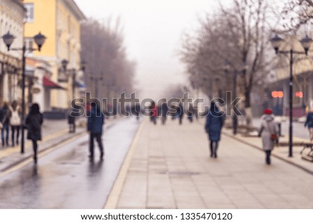 People on the street of the old city in early spring - blurred urban background