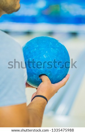 take blue bowling ball in hand