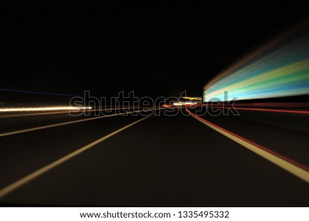Motorway seen at night, blurred street lamp lights, car lights, lines
