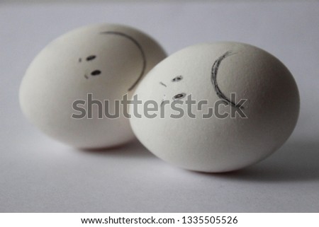 white eggs with different emotions on the white background close-up