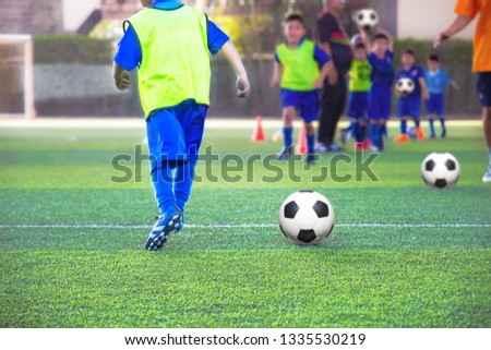 Boys move soccer practice drills with cones. Soccer drills: slalom drill. Young football players training on pitch