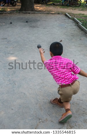  The boy playing petanque at school.