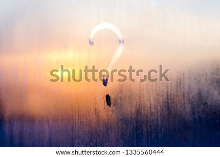 question mark on a misted window during sunset - background