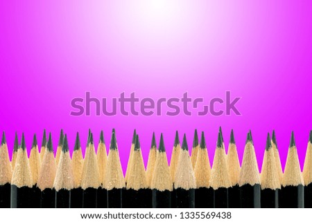 Black pencils isolated on purple background. Copy space.