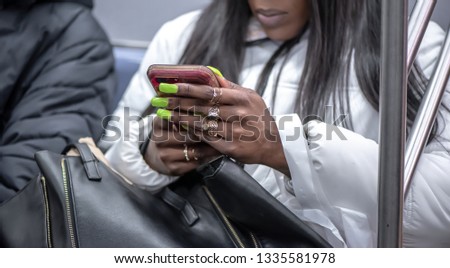 Womans hands with manicure holding smartphone, touching screen and using app