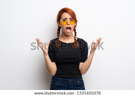 Young redhead woman over white wall frustrated by a bad situation