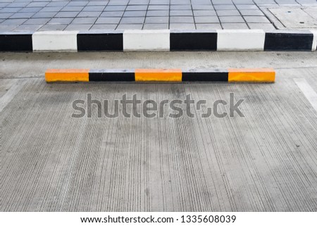 Parking space concrete floor with wheel stopper black and yellow color