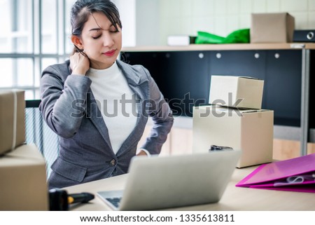 Stressed young Asian businesswoman have neck pain while working in office, work hard and office syndrome concept.