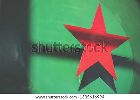 Red metal five-pointed star on a green background. Soviet national political symbol. Soviet Union