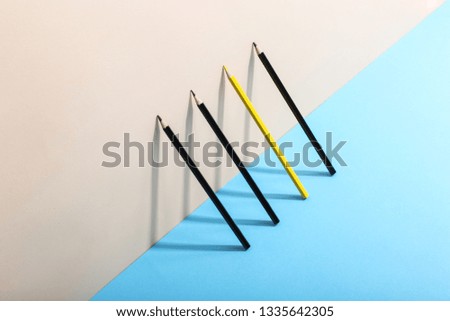 Pencils stand against the wall, casting shadow, drawing geometric shapes. One is different from all, special, concept art, minimalism.