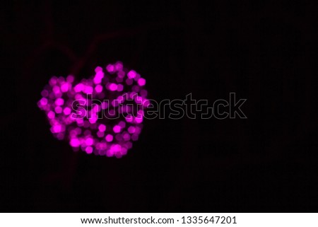 Abstract image of bokeh as heart on a black background.
