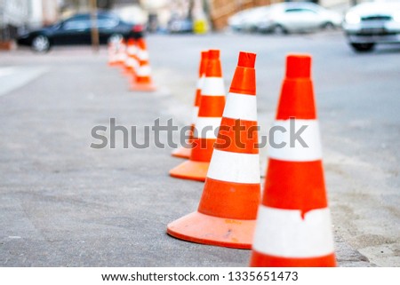 bright orange traffic cones standing in a row on  asphalt