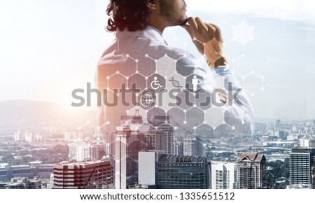 Double exposure of confident doctor in white sterile coat with modern cityscape view and media interface.