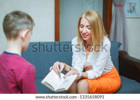 Woman psychologist speaks with a child patient