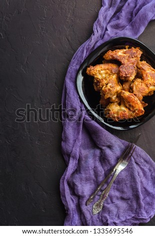 Spicy Deep Fried Breaded Chicken Wings on dark stone background.