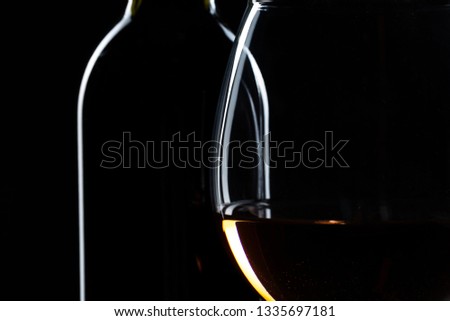 elegant wine bottles and wine glass in a black background