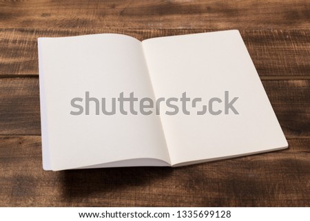 Mock-up magazine or catalog on wooden table. Blank page or notepad on wood background. Blank page or notepad for mockups or simulations