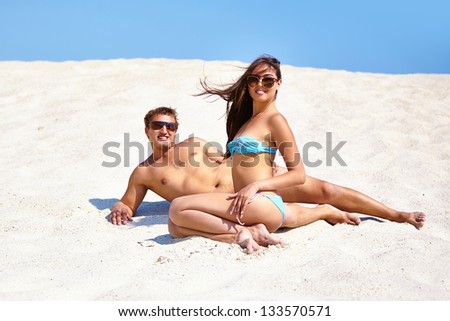 Attractive couple sunbathing on the beach