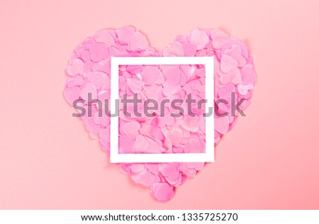 Elegant and tender pink heart of scattered heart-shaped confetti with white frame. The mood of tenderness and love.