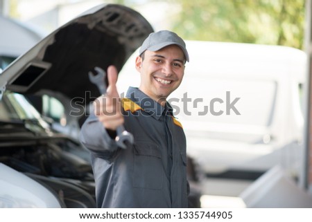 Smiling mechanic in front of a van