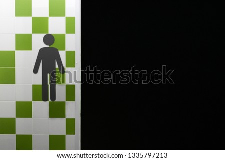 Restroom. Symbols of man on the wall with green and white squares. Public place. Copyspace. Black freespace background.