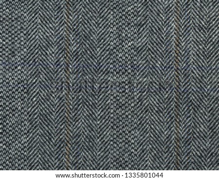 Gray woolen fabric striped zigzag. Herringbone tweed, Wool Background Texture. Coat close-up. High resolution.