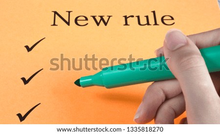 Hand writes marker on orange paper, text, message, new rules, art, study, creativity, design