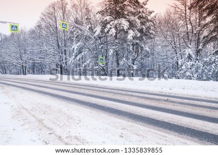 Winter landscape with an empty asphalt road going through the forest