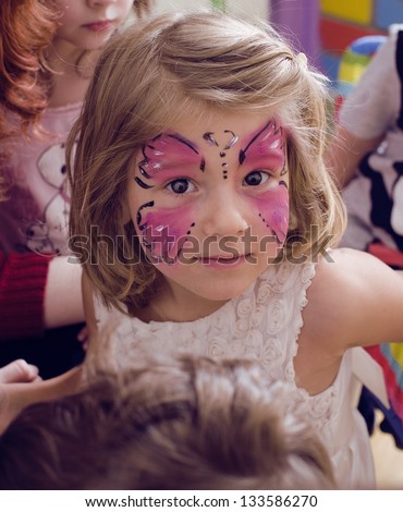 little girl with faceart on birthday party Royalty-Free Stock Photo #133586270