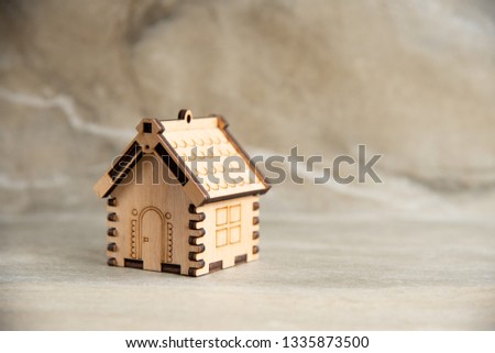 Miniature of wooden house standing on marble stone background. Copy space.  Studio photo.  Mortgage concept. Symbol House. Real estate concept. Eco Friendly House.  